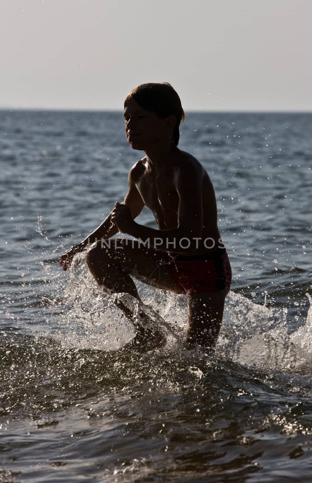silhouette of jumping boy into the sea