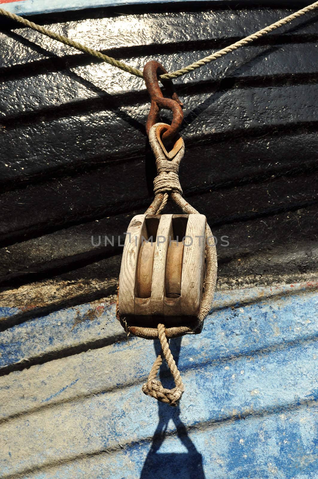 Old wooden block hanging on the side of a boat.