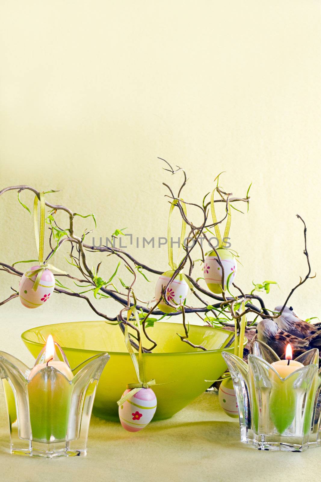 Easter decoration with branches, green bowl and candles - vertical