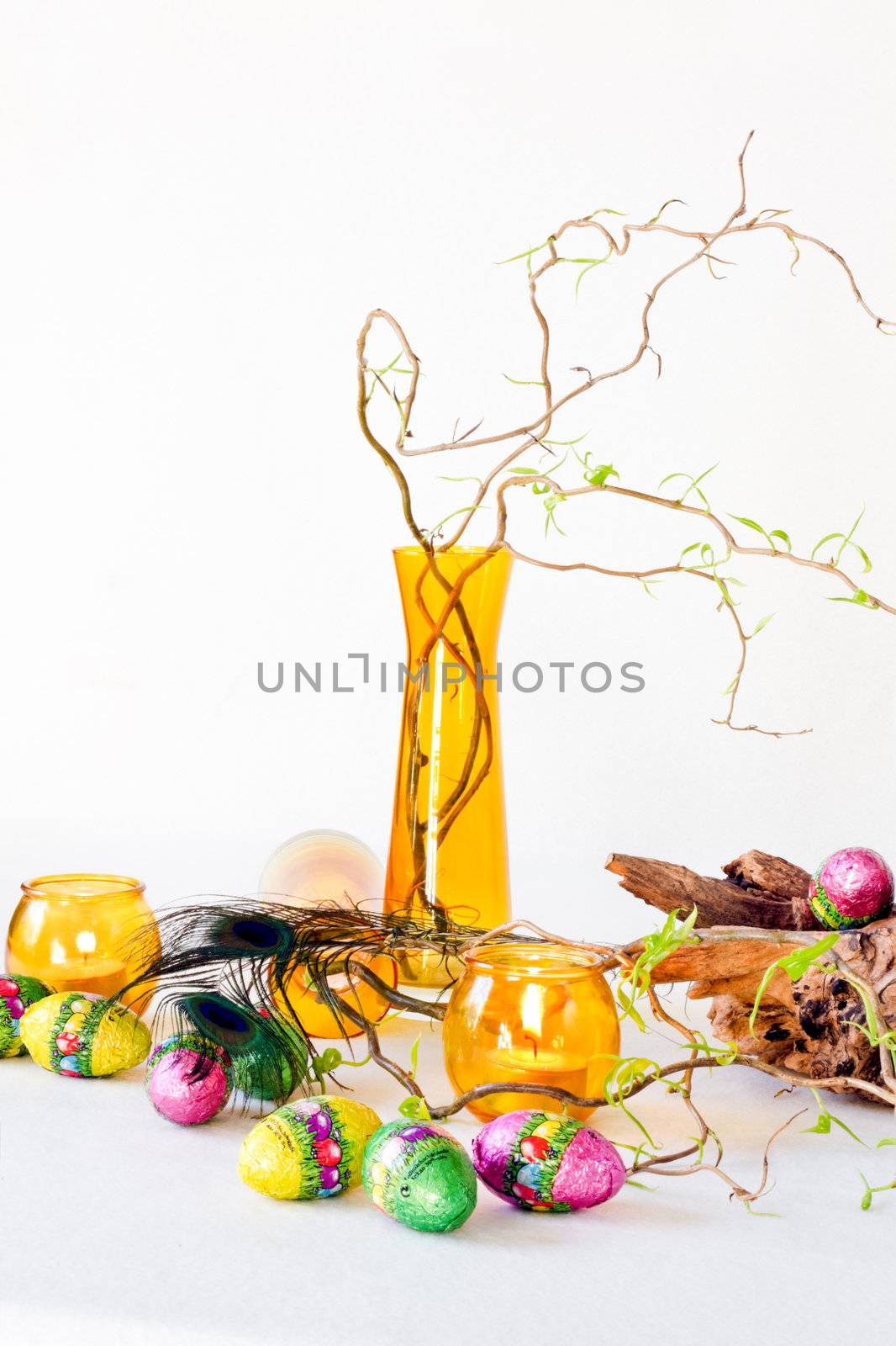 Easter decoration with yellow glass-ware and chocolate eggs - vertical