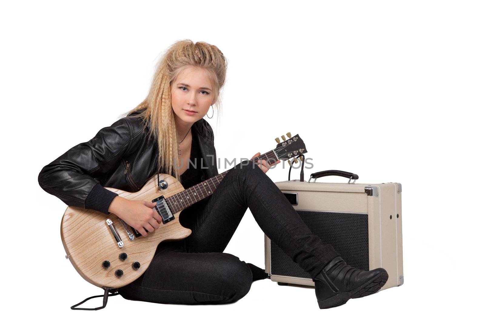 Blond rock teenage girl playing an electric guitar on her knees. Studio shot, isolated on white background.