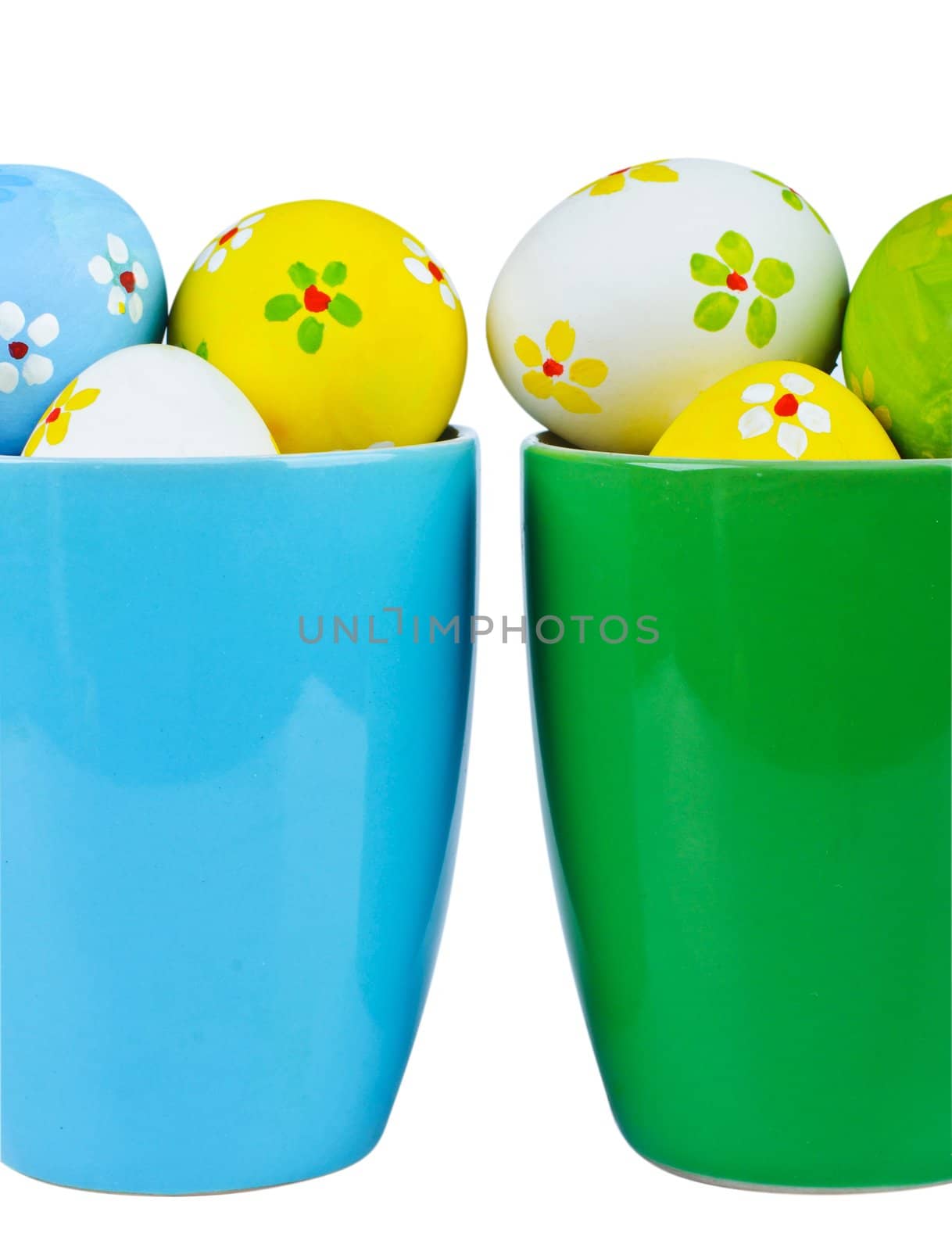 Polka dot easter eggs in cups on white background