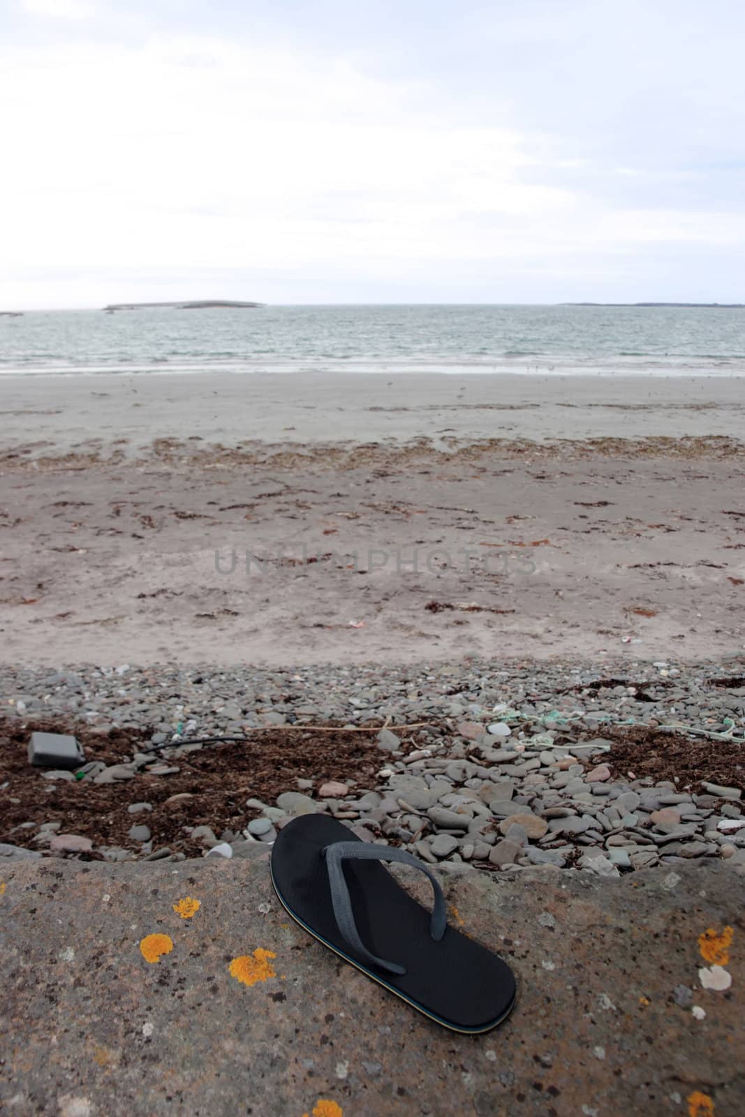 a single flipflop washed up on the beach in ireland