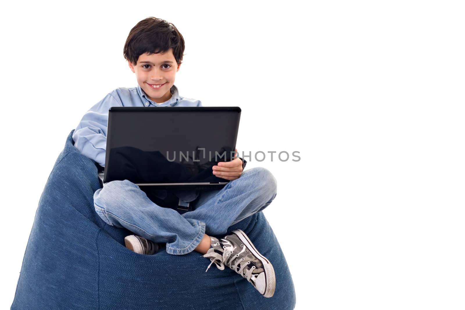 Cute kid sitting using a laptop over white background