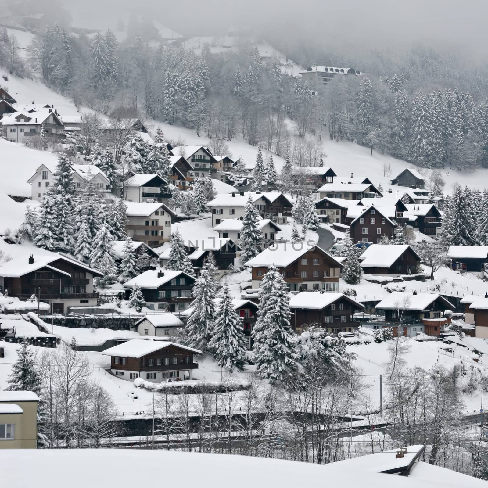 View over a Swiss Village in the Alps, covered in snow during winter.