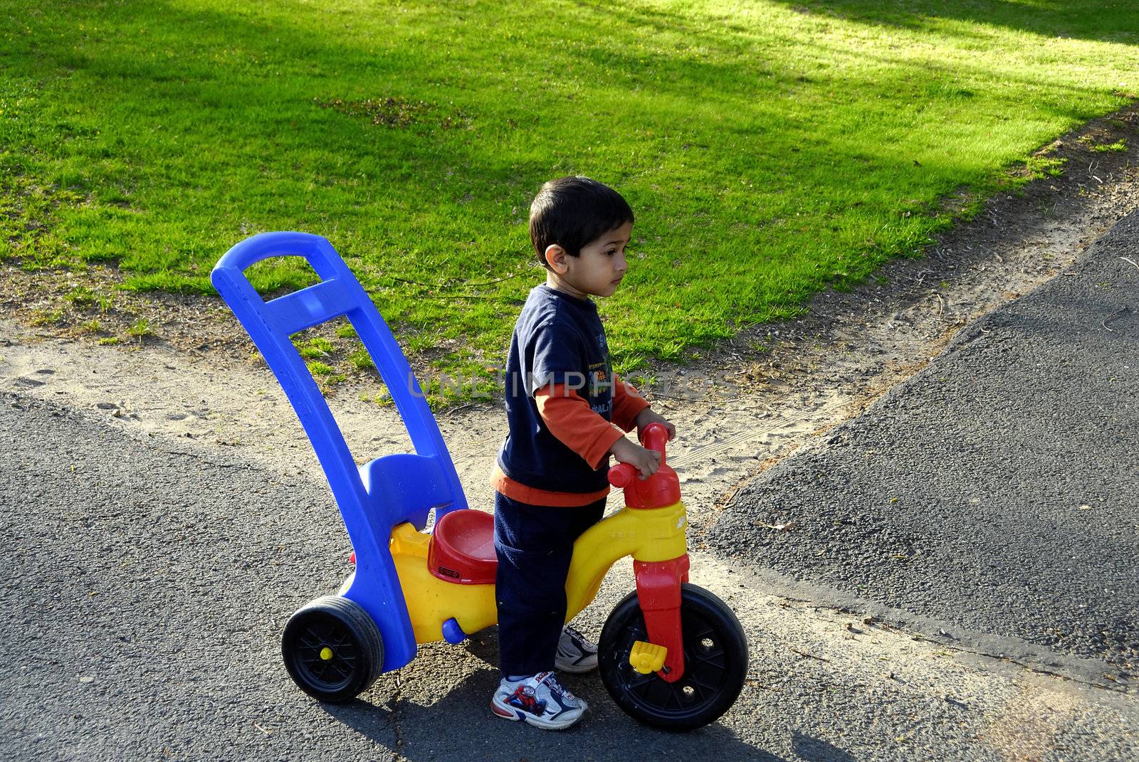 A kid habing fun with a tricycle