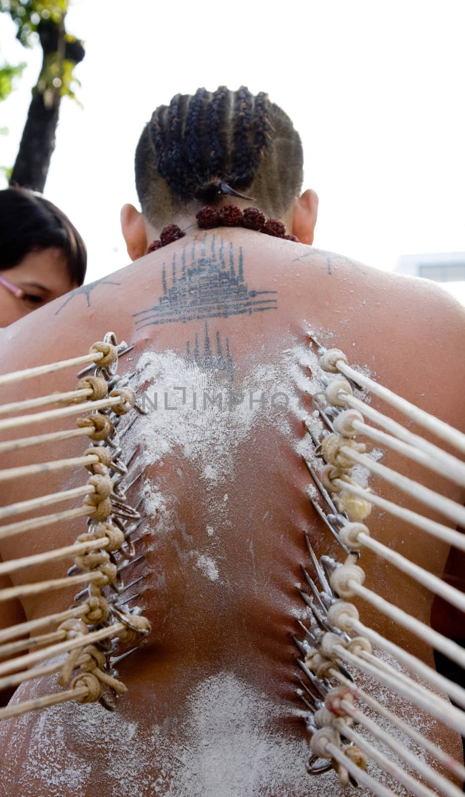 a devotee of thaipusam with hooks pierce through their backs in their beliefs