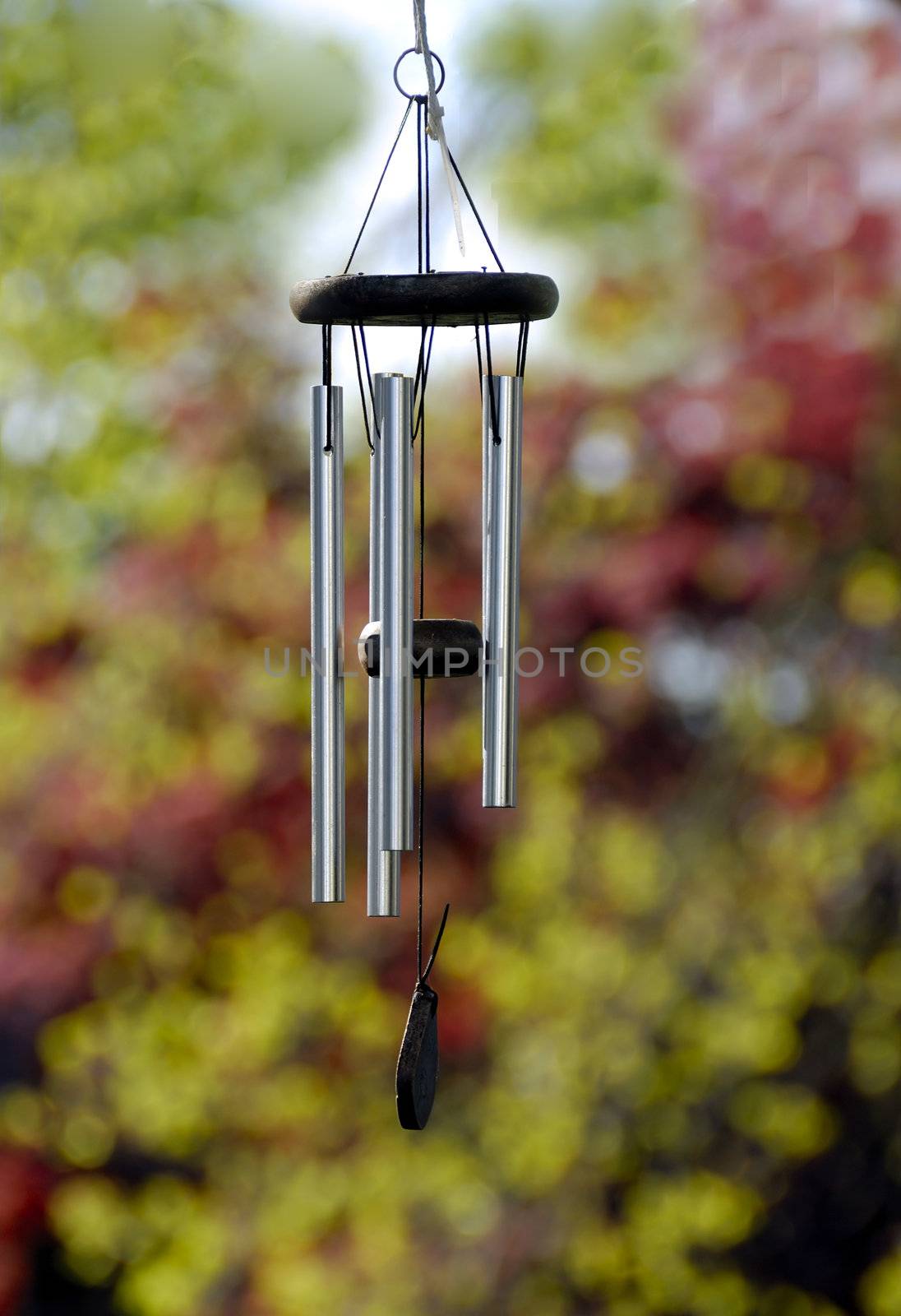 A metal wind chimes against a nature back ground
