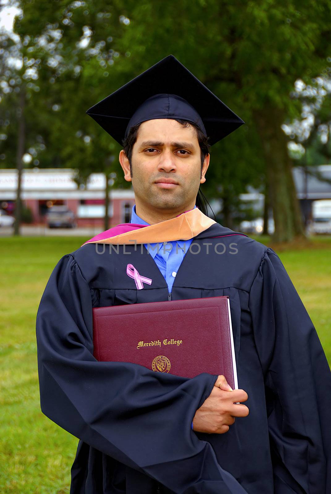 A graduate proudly holsding his degree certificate