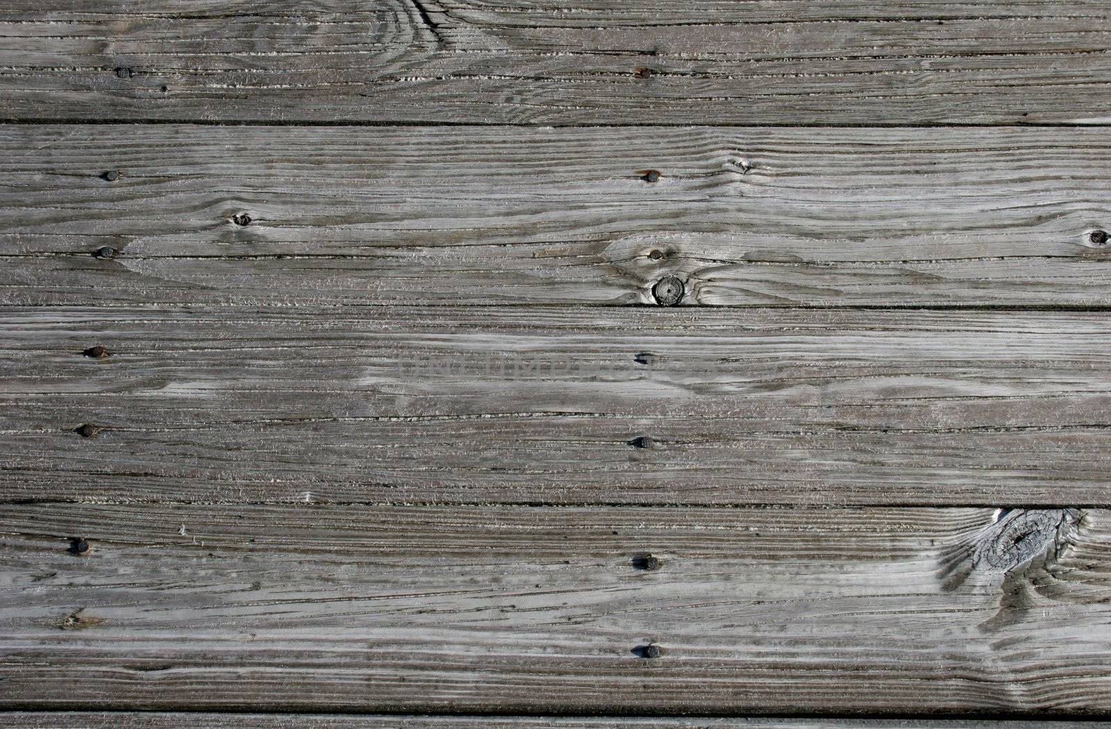 Close up of sandy, weathered planks on beach walkway