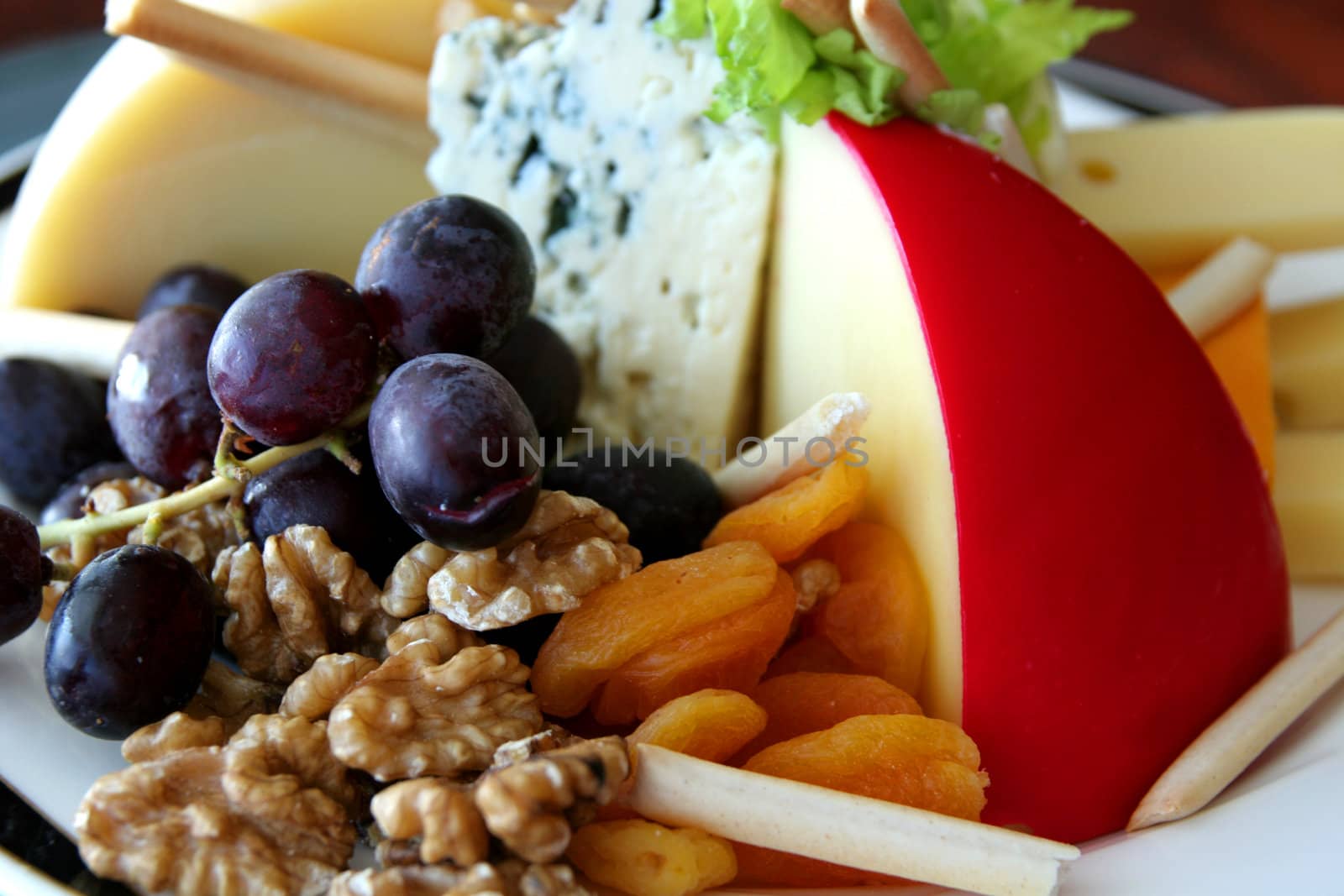 A fruit, nut, and cheese tray in a buffet