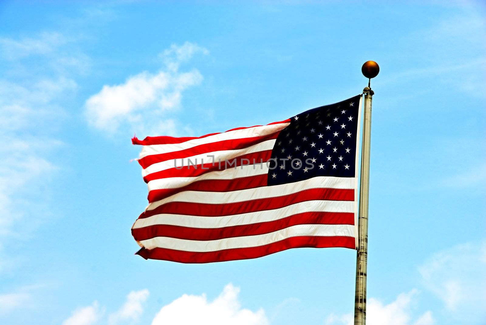 An American Flag flying high on a sunny day