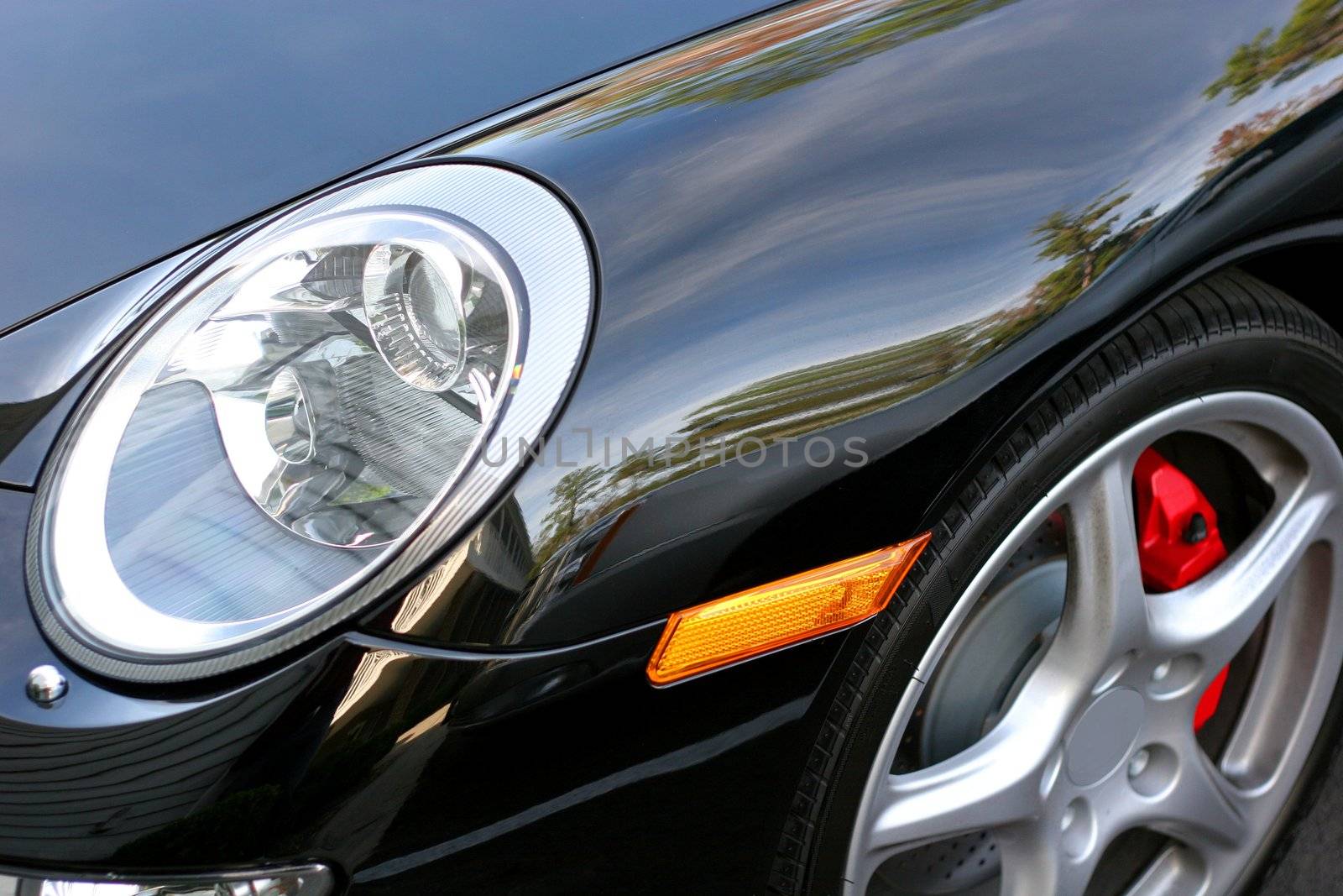 Close up of headlight and fender of black German sports car