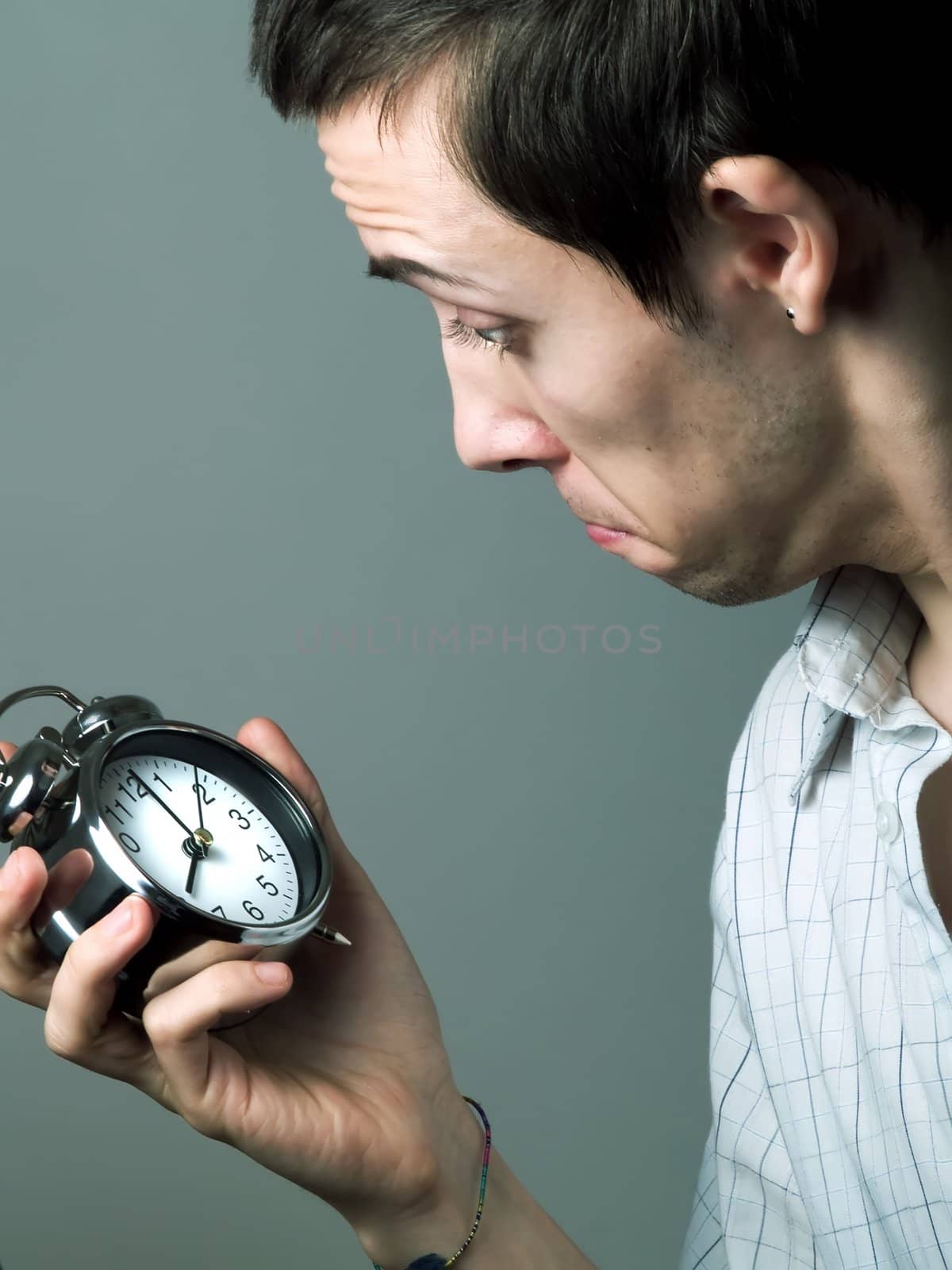 Young man holding an alarm clock