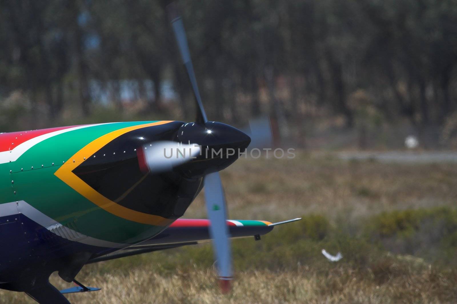 A prop plane with the nose painted in the colors of the South African Flag