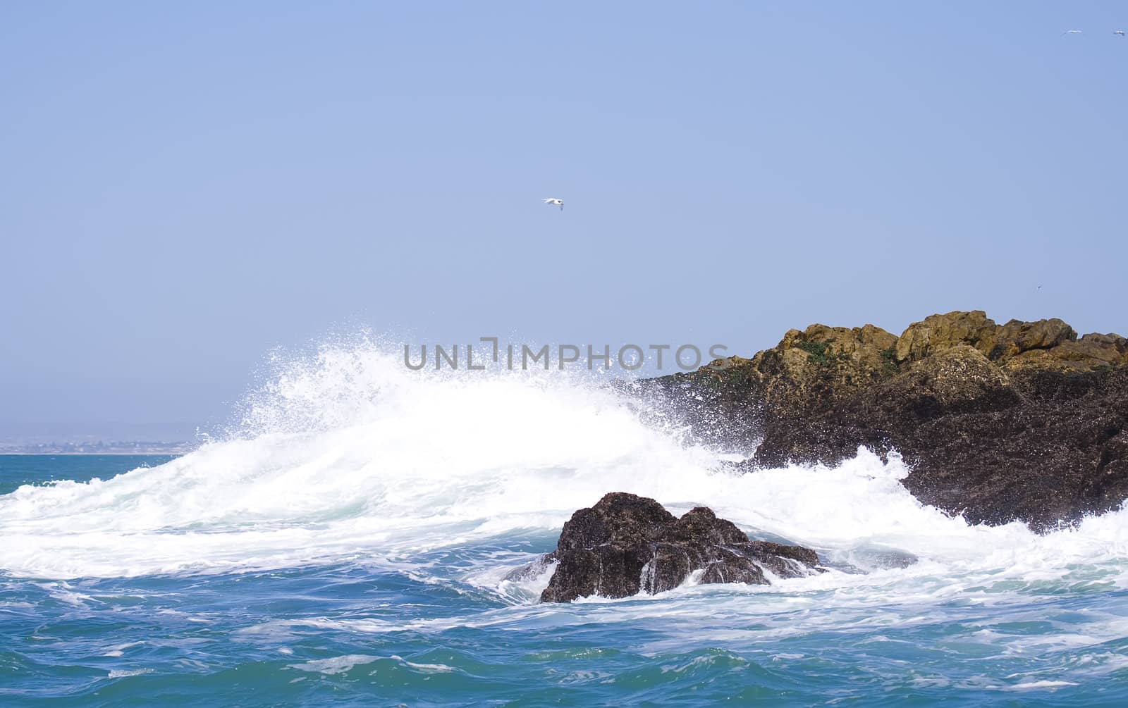 Powerful wave crashing up against the rocks in the middle of the ocean