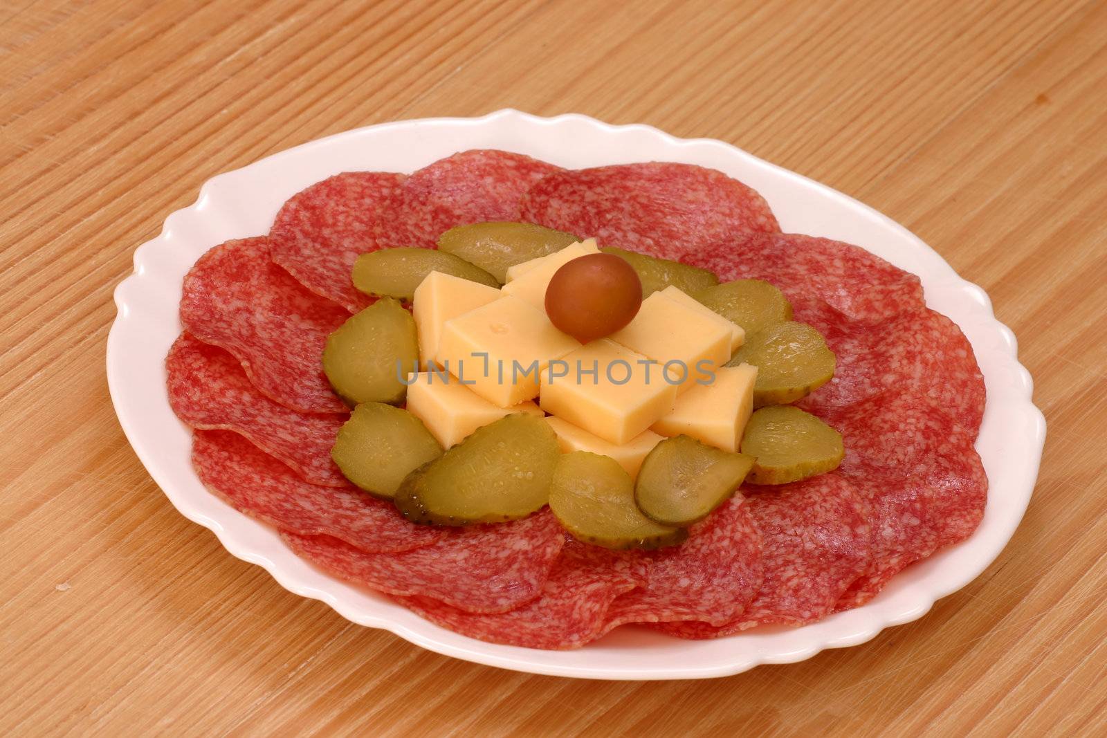 Salami on plate decorated with cheese and cucamber