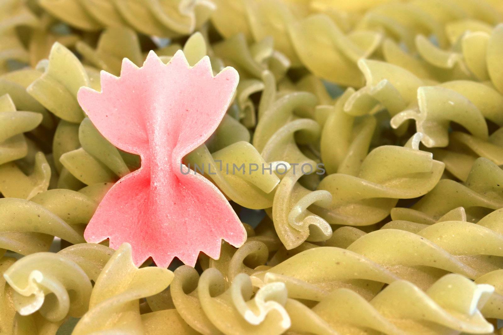 Bunch of raw pasta with one colored pasta