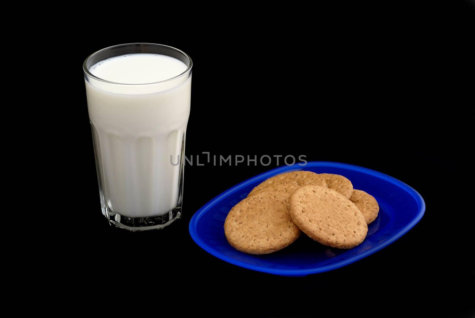 Milk and cookies isolated on a black background.
