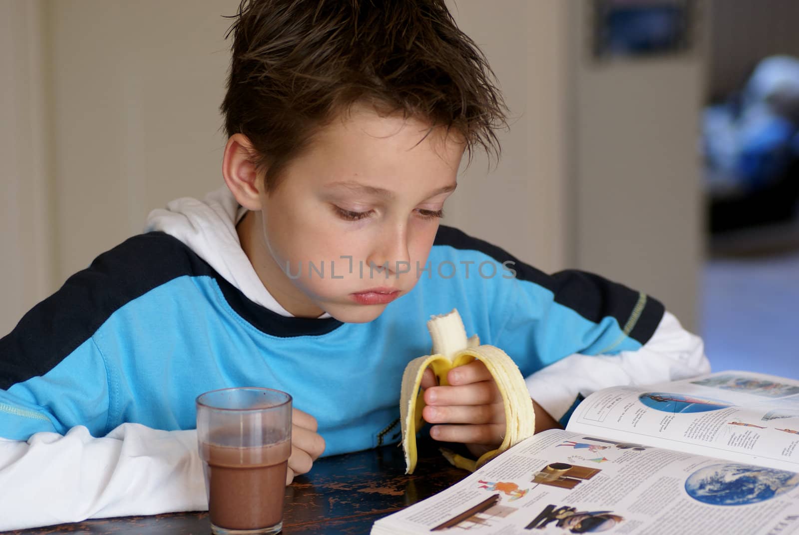 Young boy reading an encyclopedia.