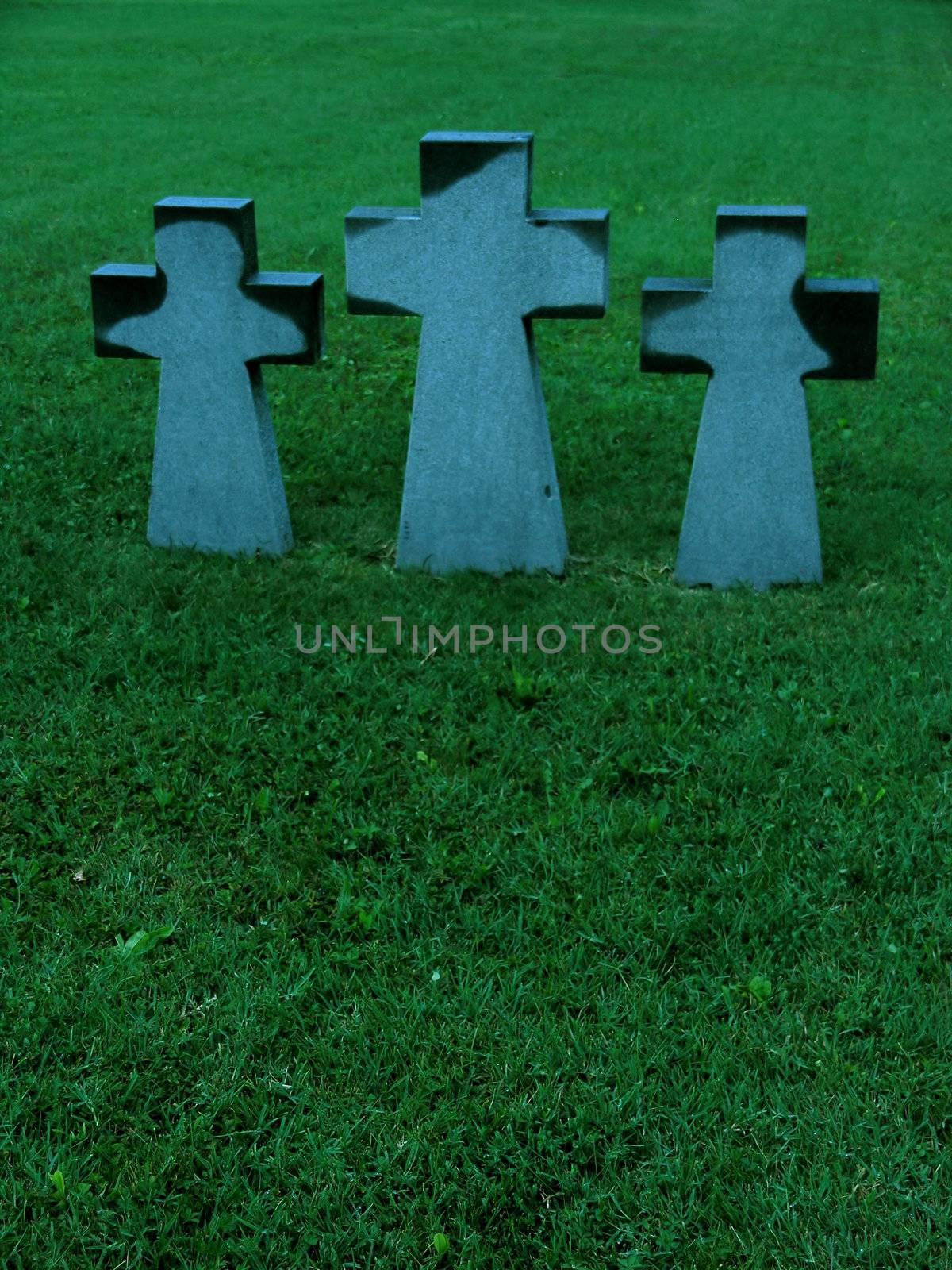 Three crosses on a meadow in cemetary