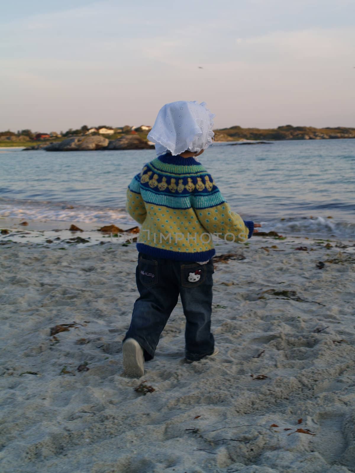 baby walking towards ocean