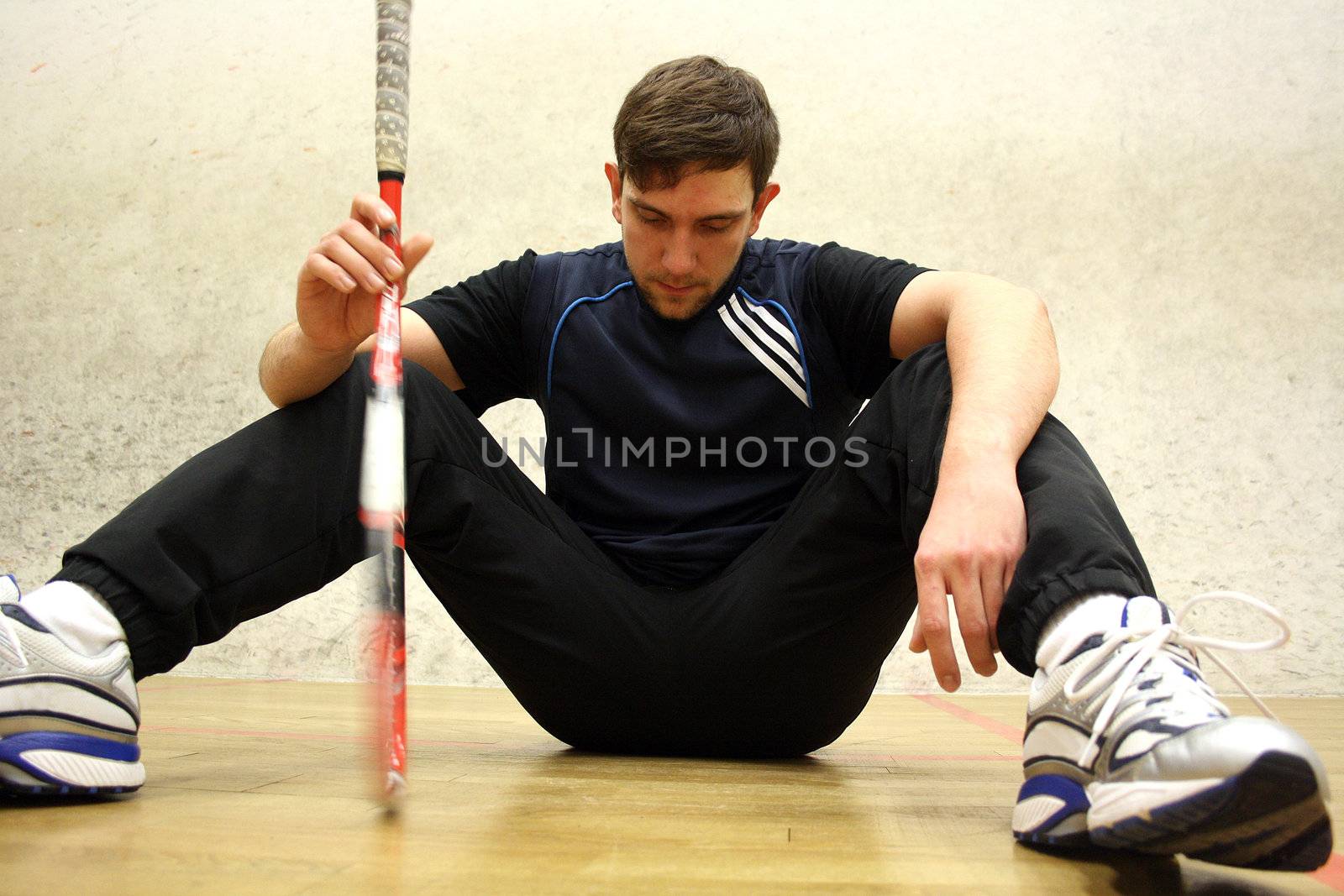A handsome man playing squash in the hall 