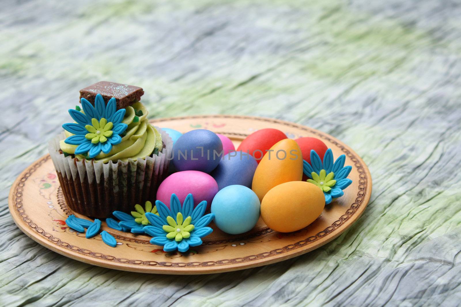 Chocolate cupcake with colorful easter eggs on an ornate plate