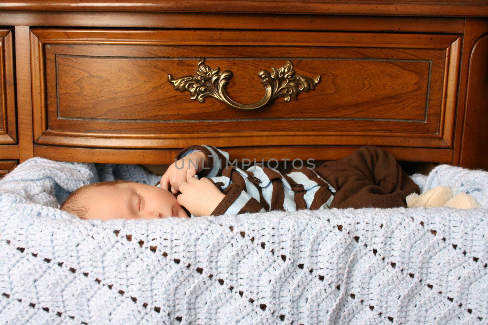 One month old baby boy sleeping in a drawer