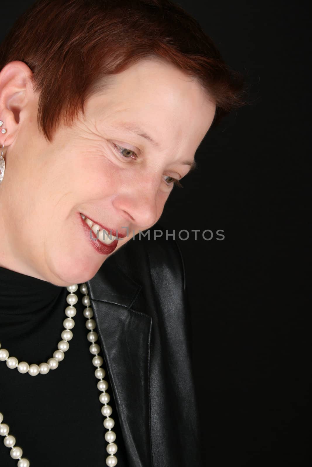 Stylish adult female wearing black leather jacket with pearls