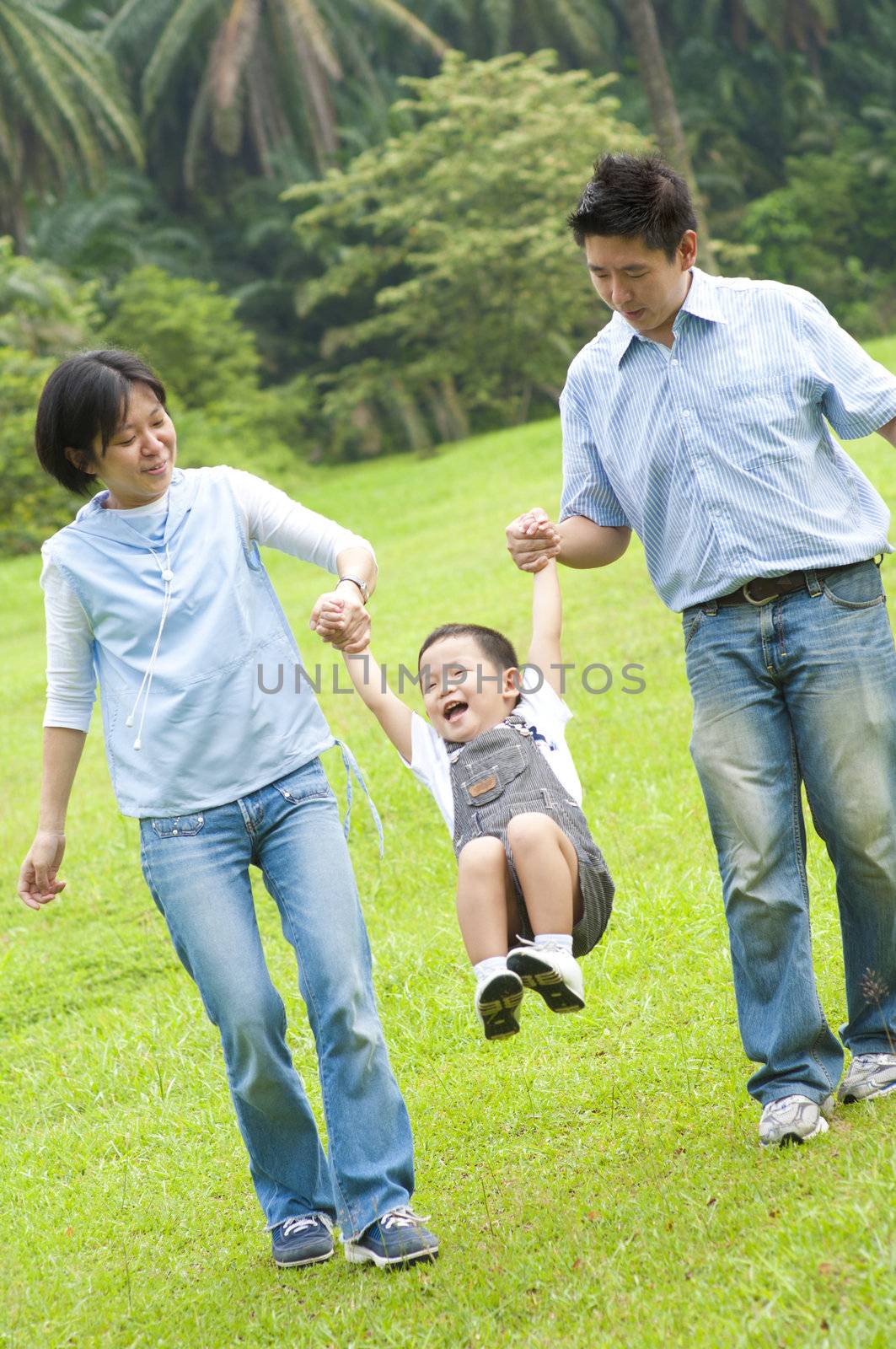 Happy Asian family walking in the park