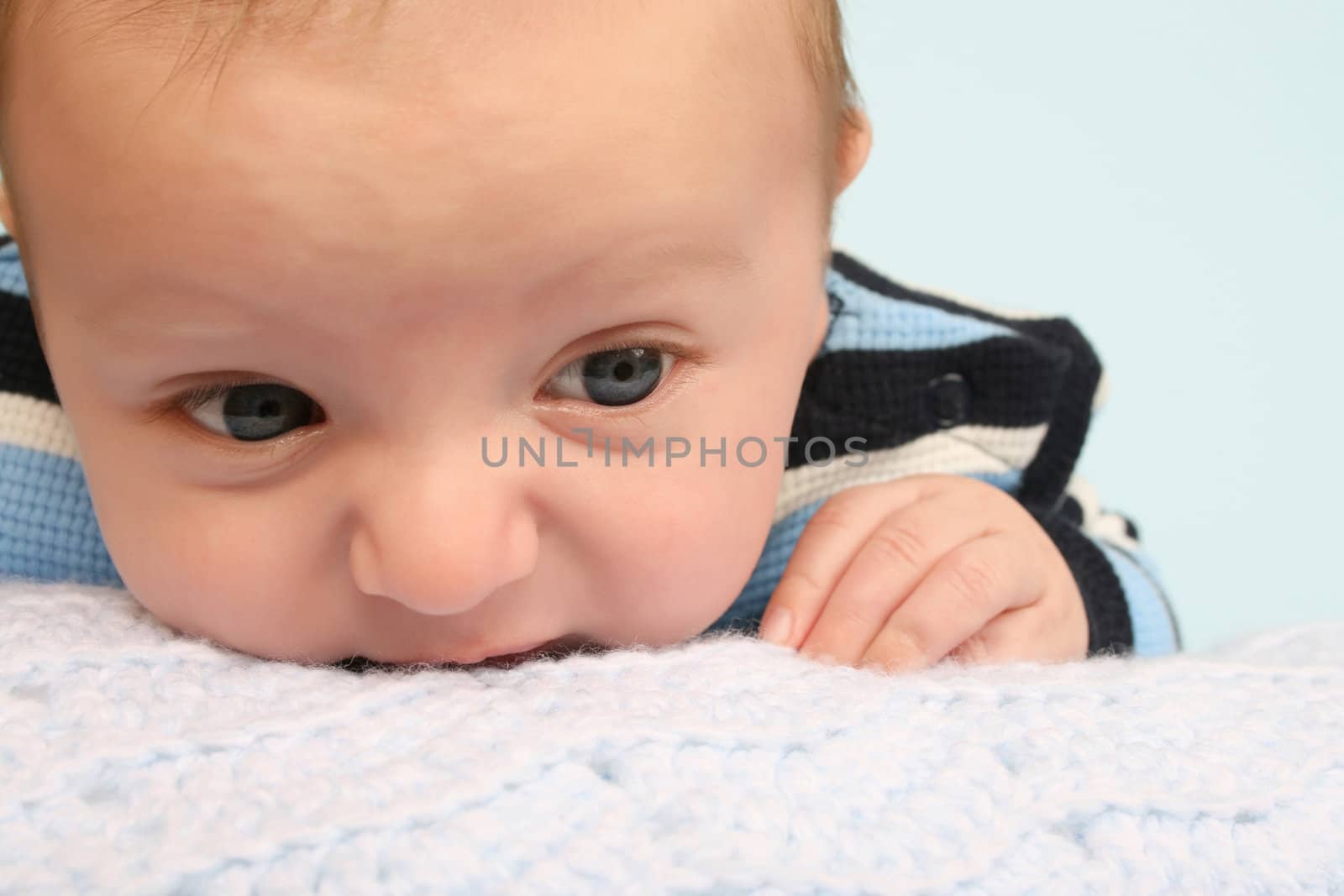 Two month old baby boy lying on his stomach