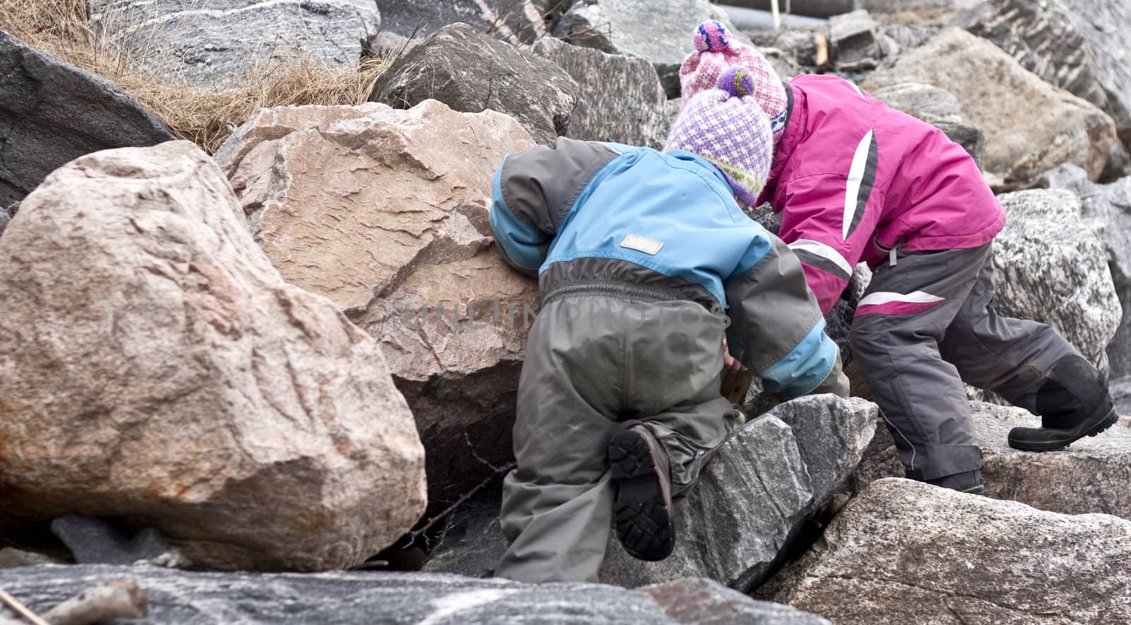 Children searching for treasures between large rocks