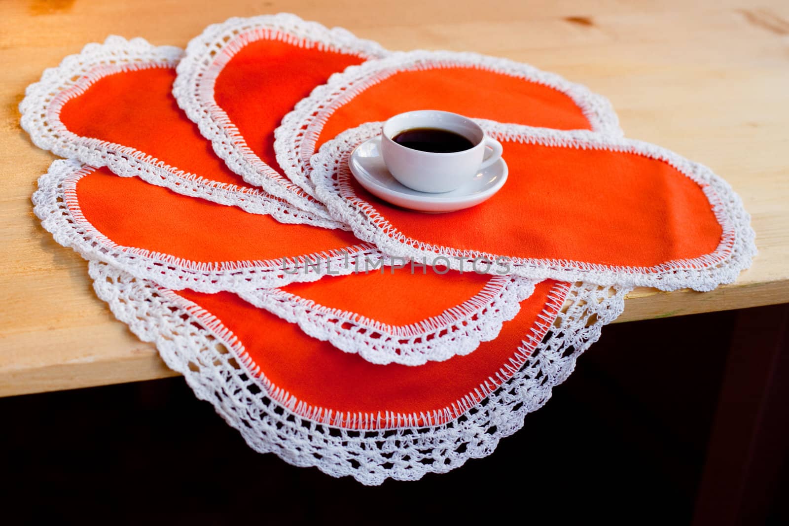 A coffee cup on several orange napkins
