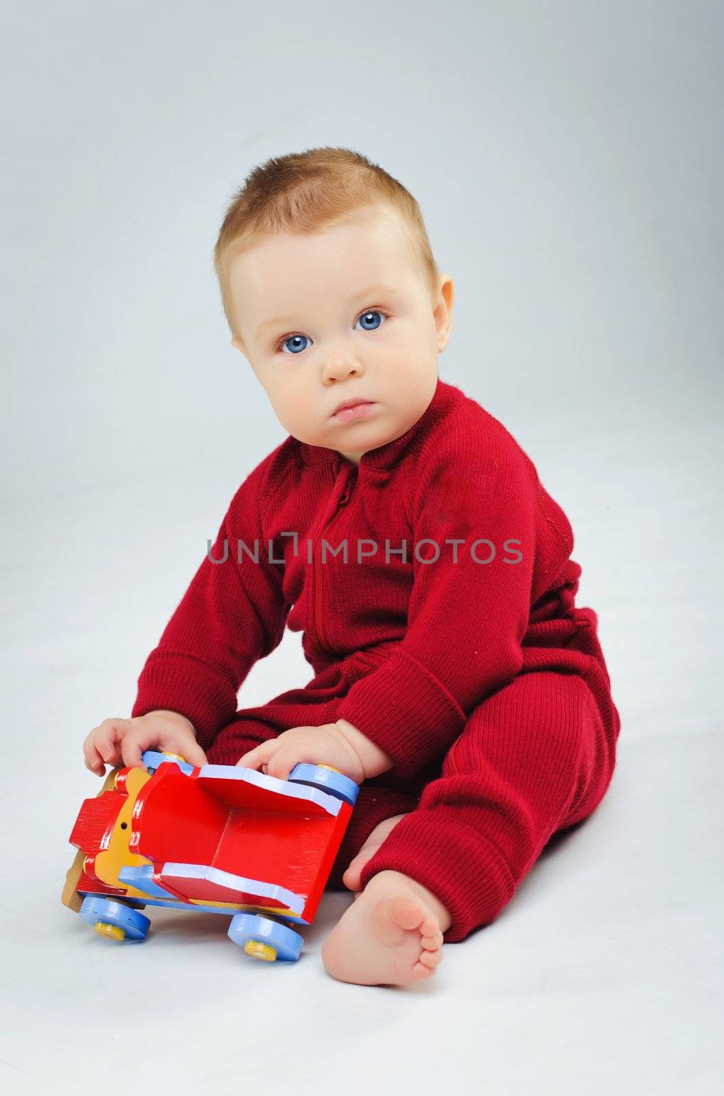 baby boy plaing his toy car in studio