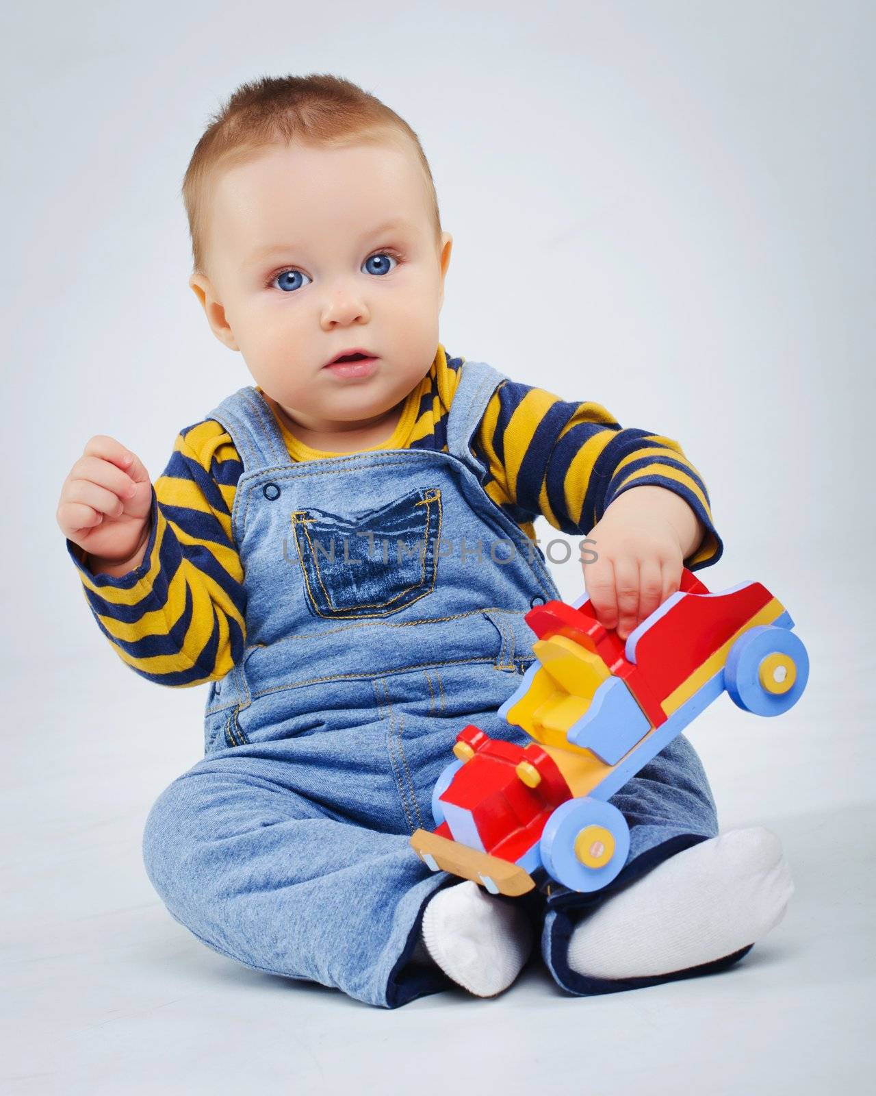 baby boy plaing his toy car in studio