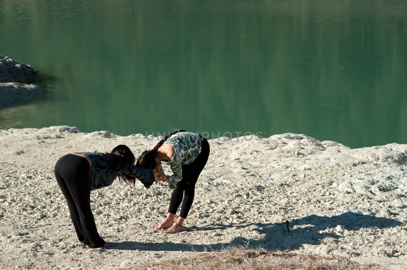 Mother and daughter, early morning yoga lakeside