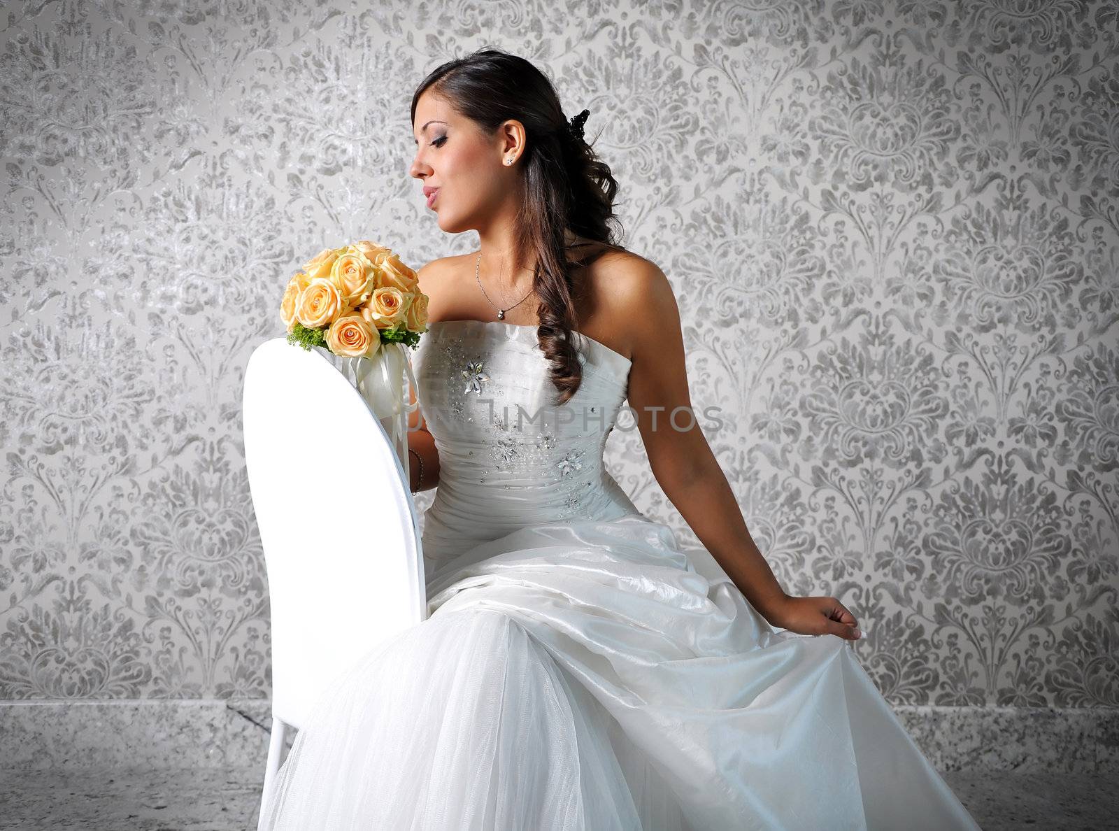 A lovely bride looks down at her bouquet. 