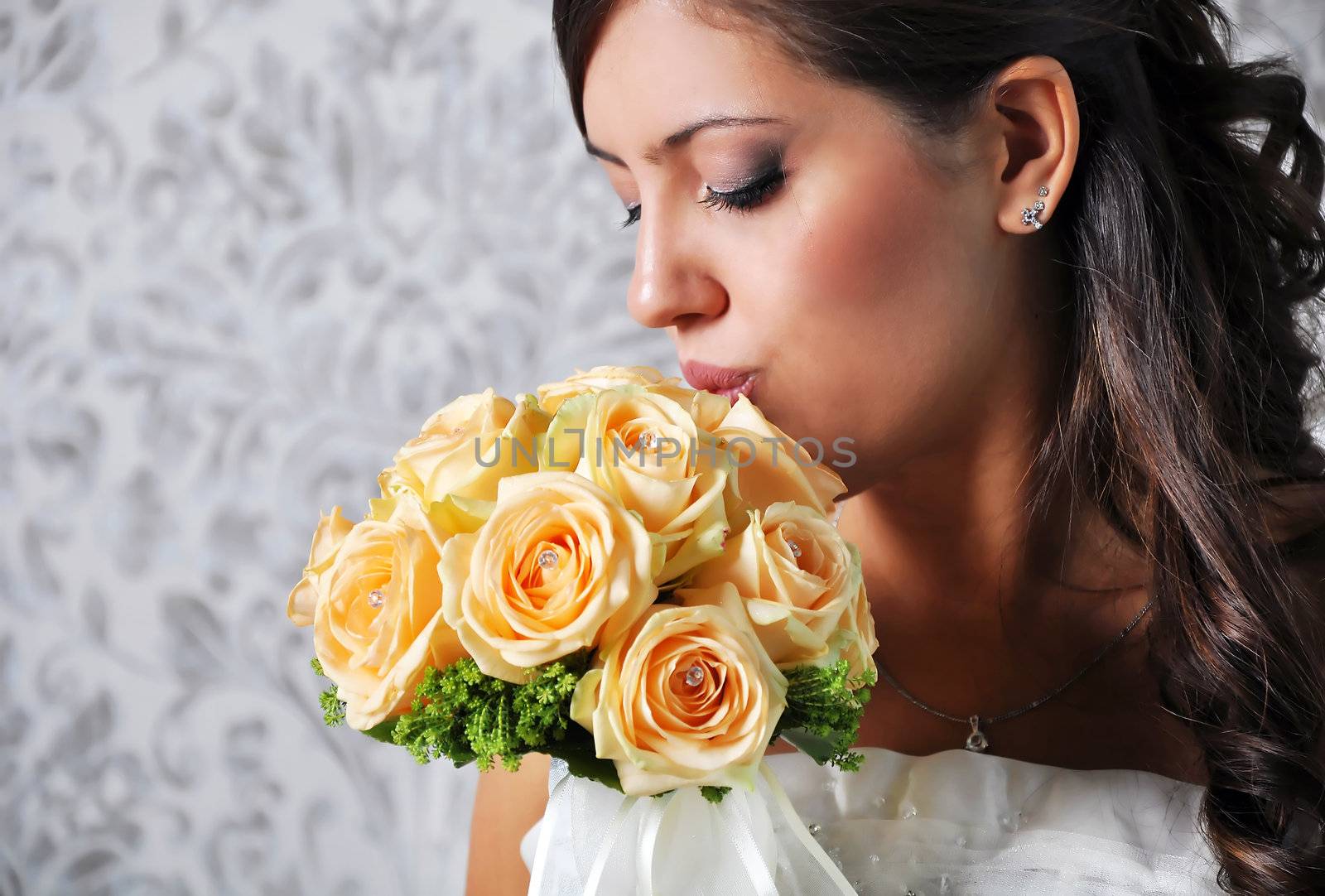 A lovely bride looks down at her bouquet. 