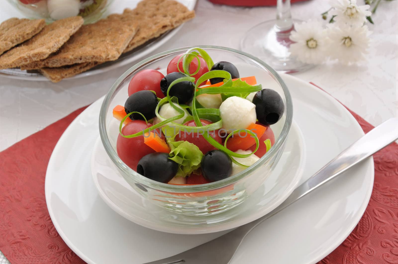 Salad of lettuce, cherry tomatoes, olives and mozzarella with pepper