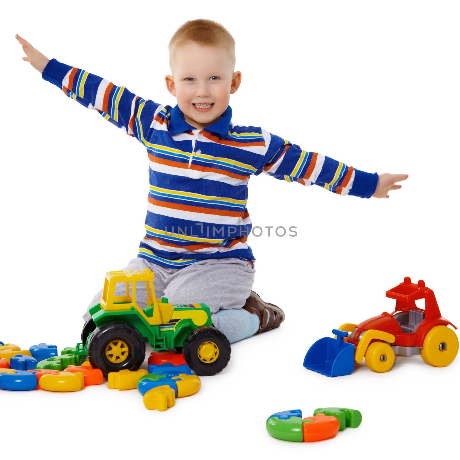 Little boy playing with color toys on floor by pzaxe