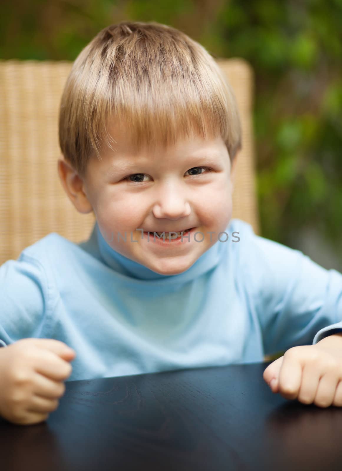 Portrait of a blond little boy with roguish smile