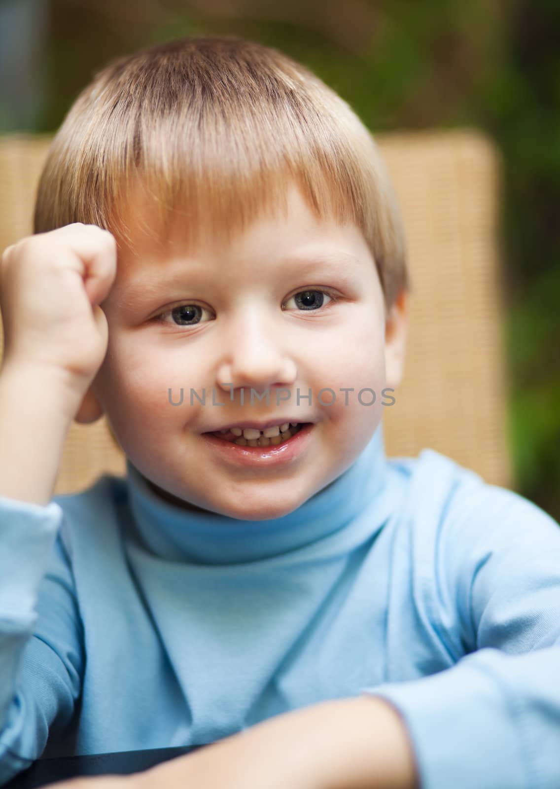 Portait of a cute smiling blond boy photographed indoors