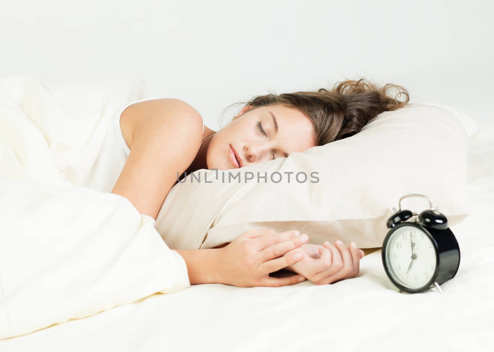 Pretty young woman sleeps in her bed