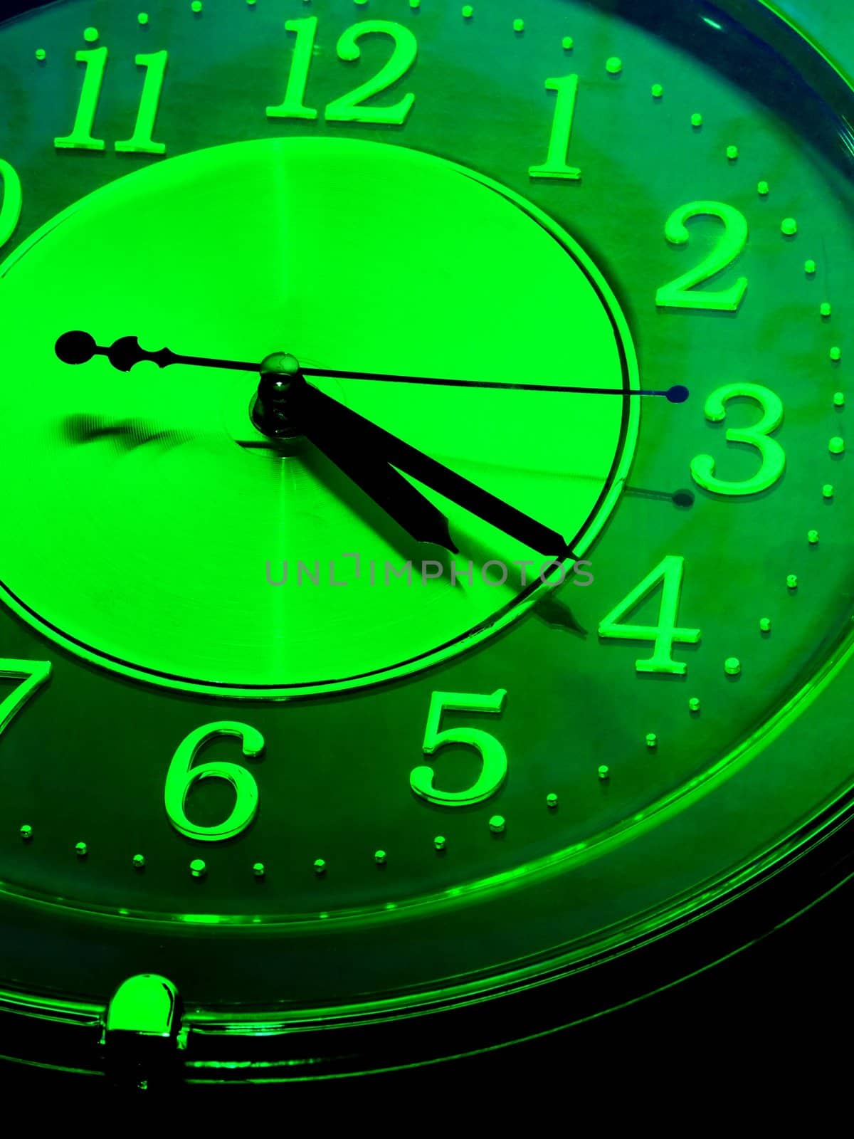 detail of an analogue clock in green tone