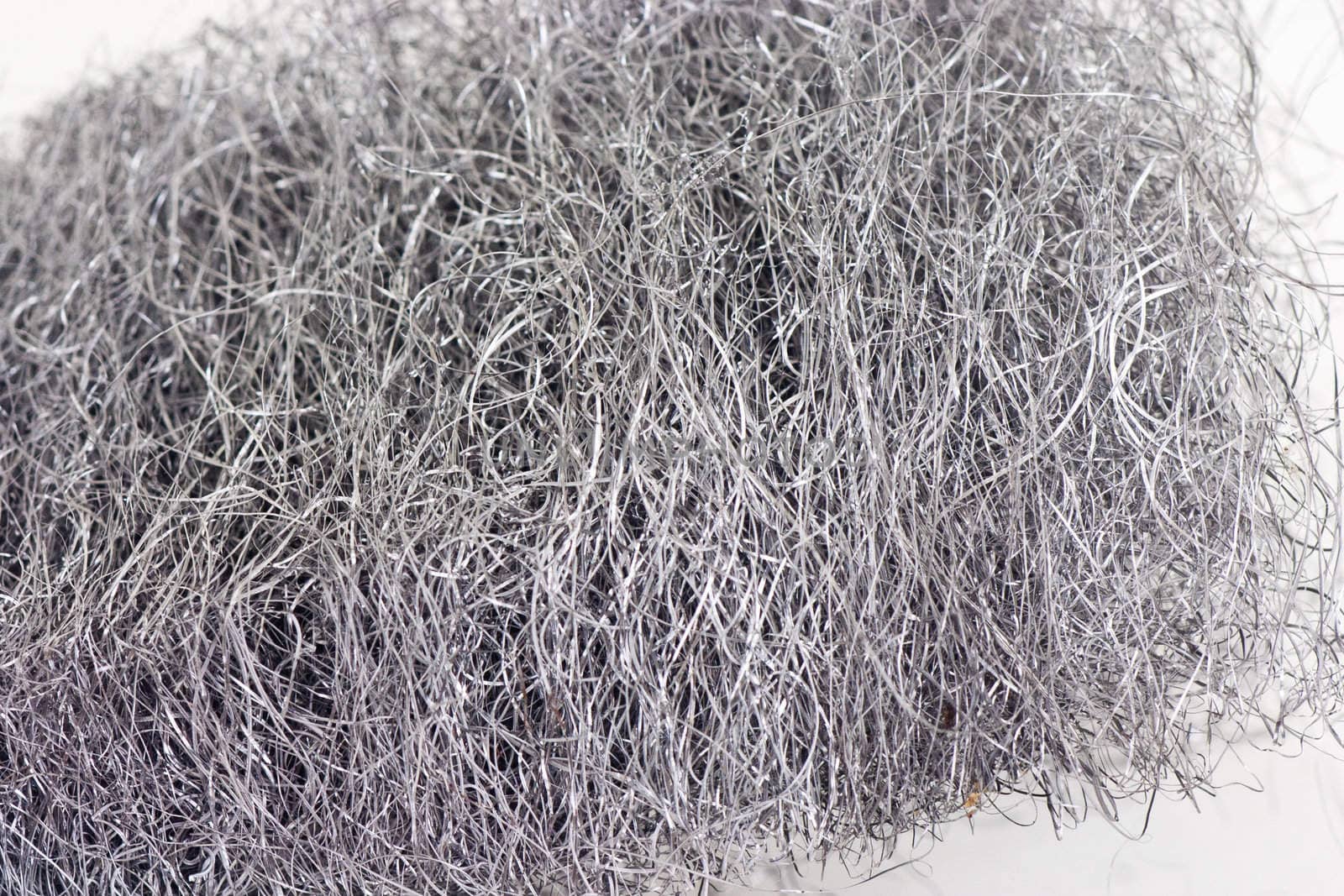 Closeup of a roll of steel wool on a white background.