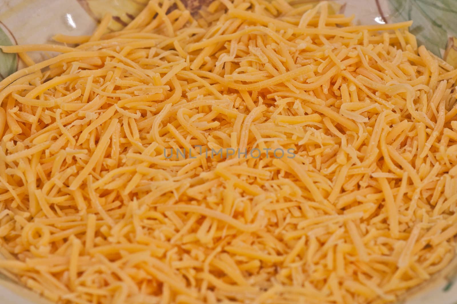Plate of chedar cheese shredded in apile.