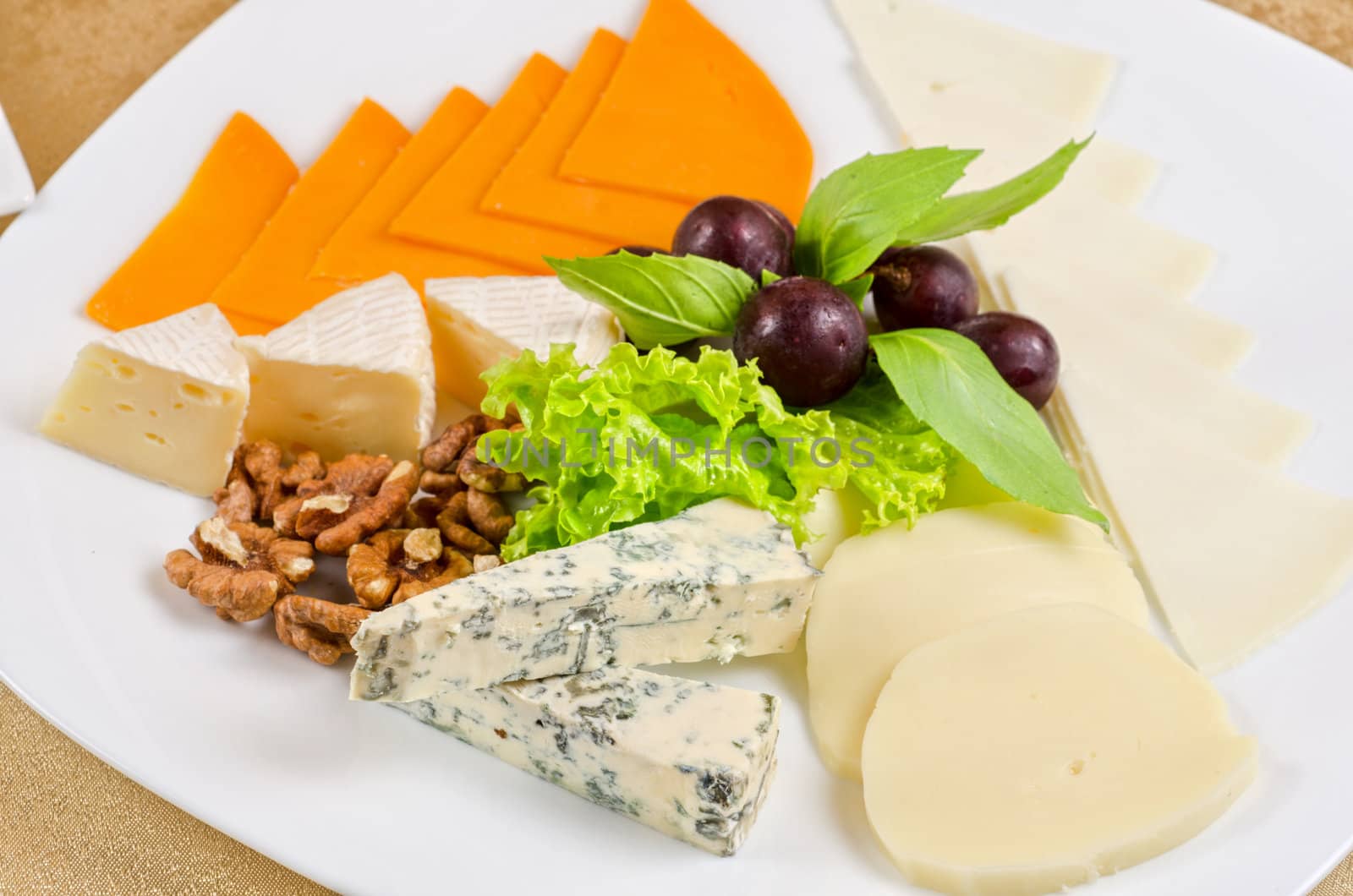 cheese with lettuce, grapes and nuts closeup