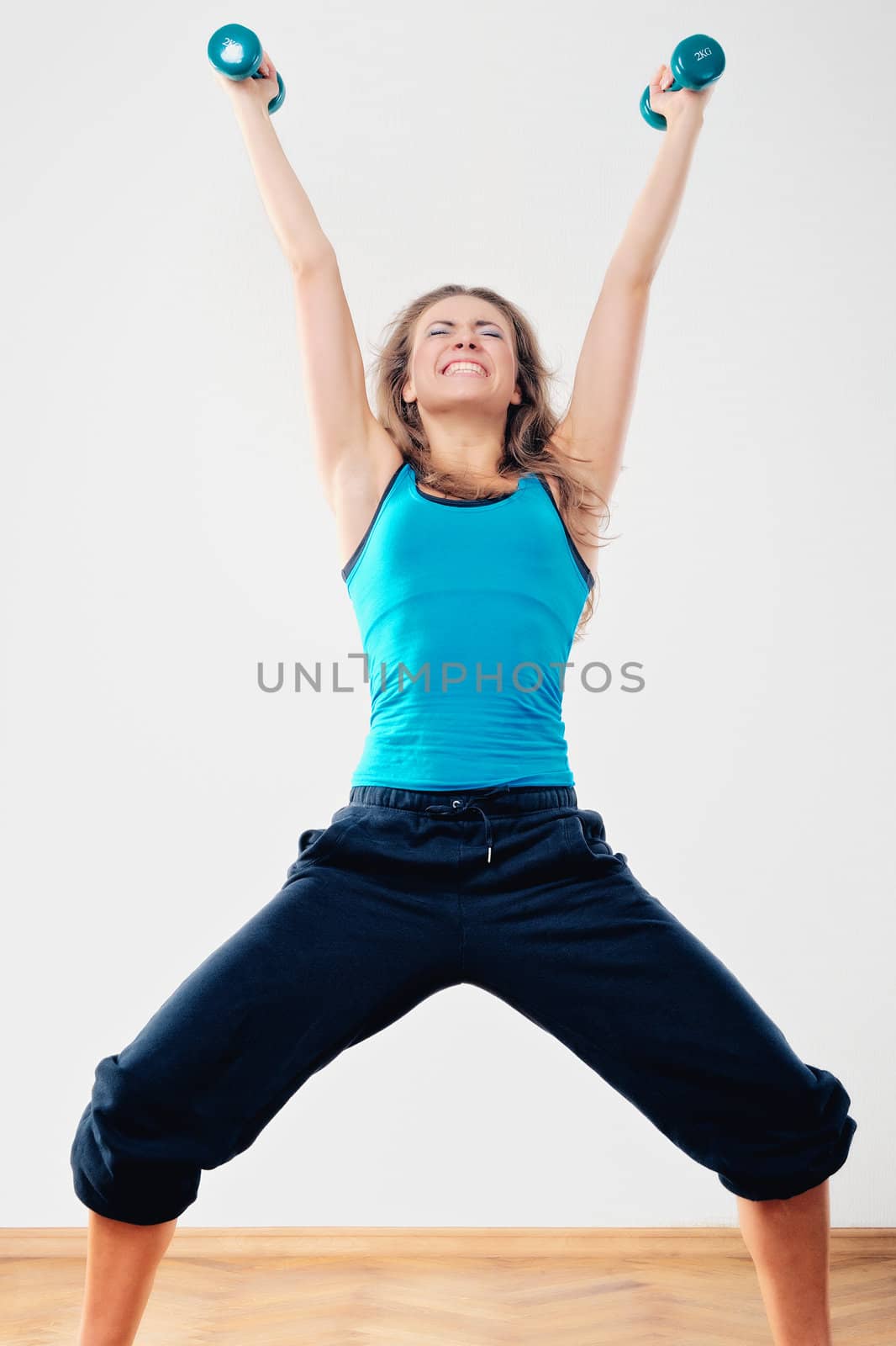 Young woman to training of athletic exercise with dumbbells