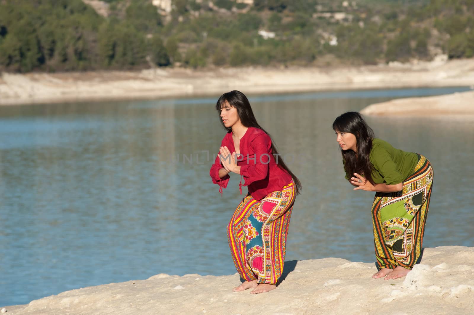 Mother and daugher at early morning yoga exercises